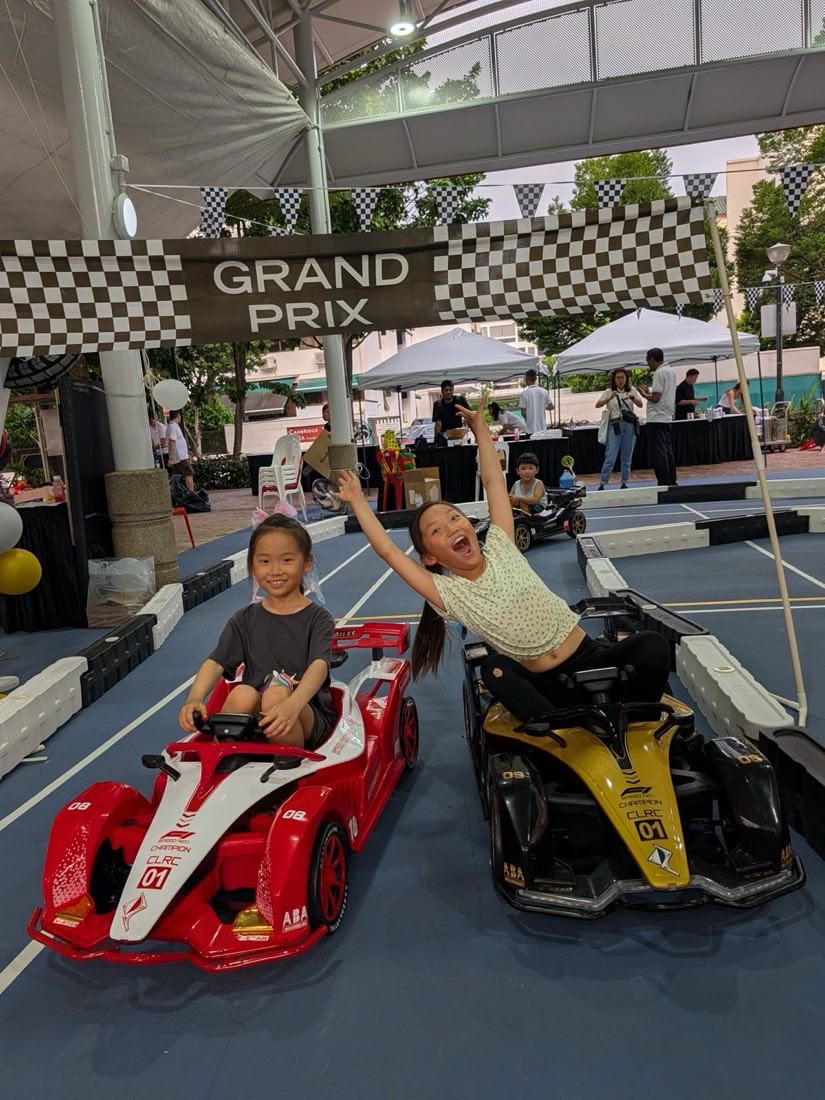 A young rider throwing both arms up in celebration beside a friend on the start line